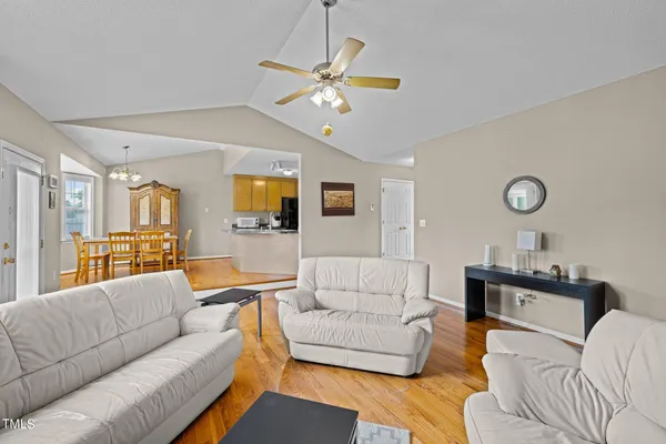 a living room with furniture kitchen view and a large window
