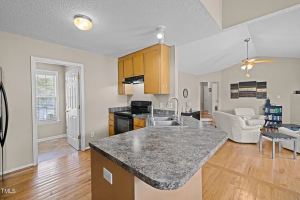 a kitchen with a table chairs and wooden floor