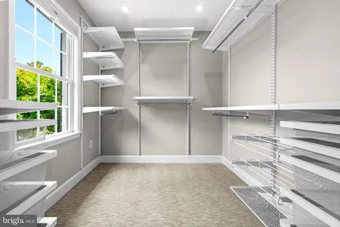 a spacious bedroom with a bed and a chandelier