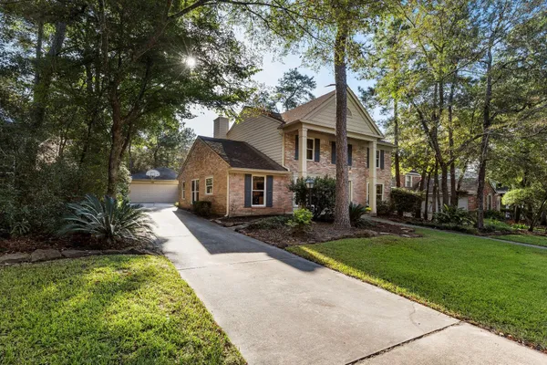 a view of a house with a big yard and large trees