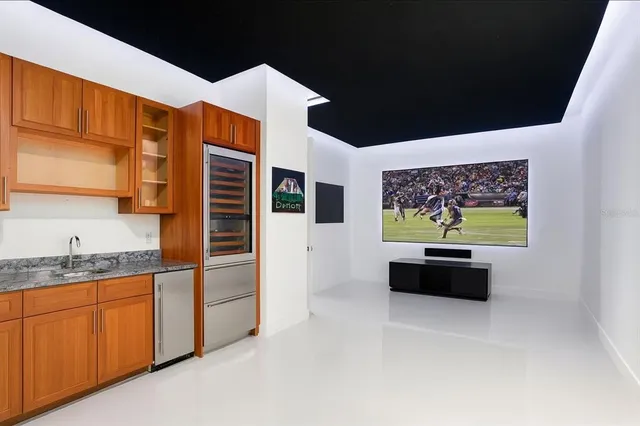 a kitchen with stainless steel appliances kitchen island granite countertop a refrigerator and a stove top oven