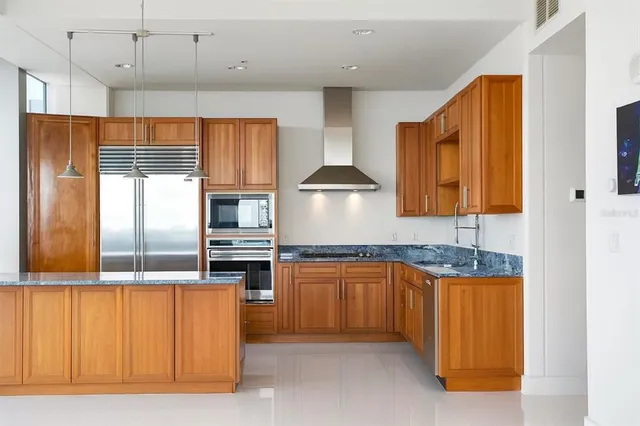 a kitchen with stainless steel appliances granite countertop a stove a sink and a refrigerator
