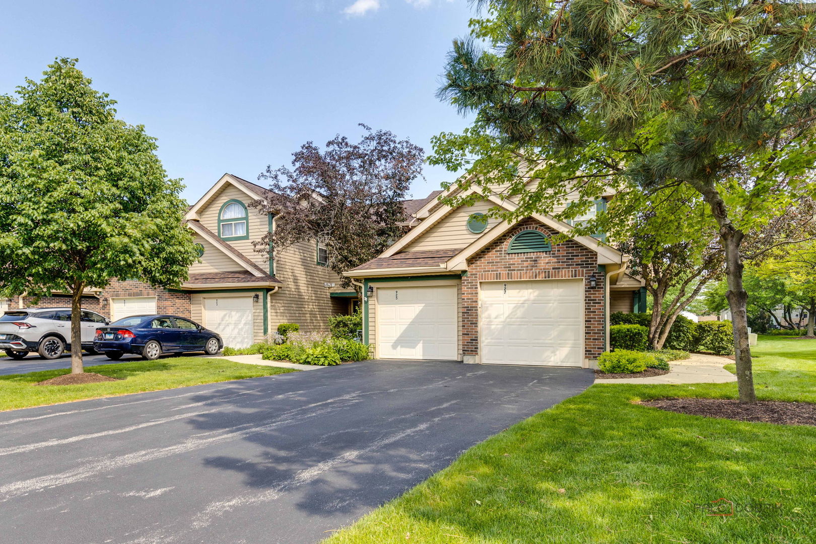 a front view of a house with a yard and trees
