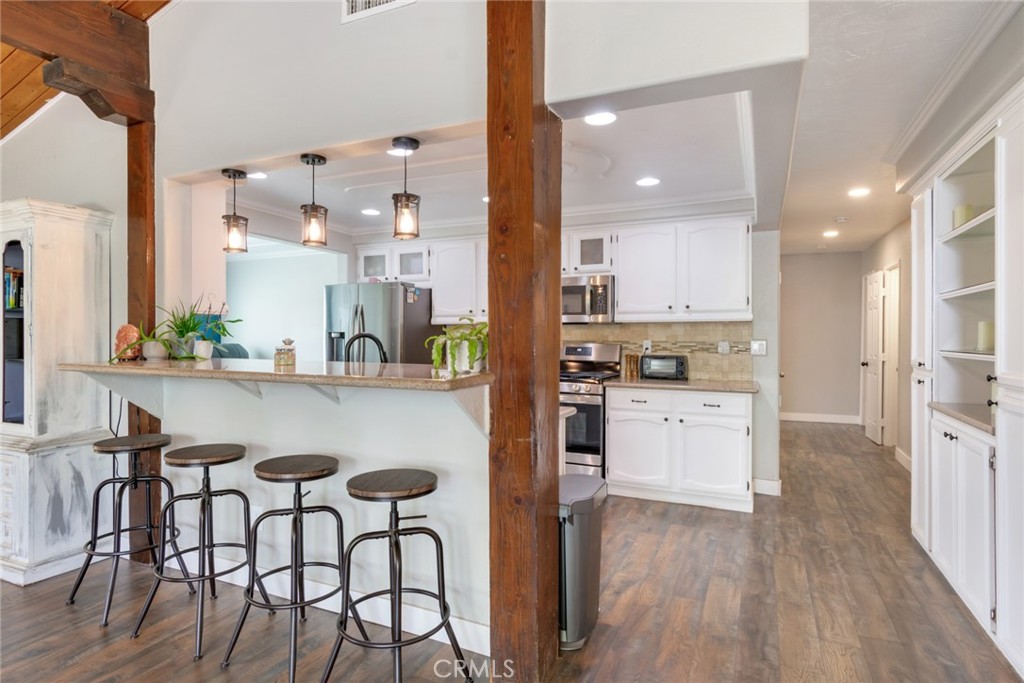 20970 Rider Street Perris, CA 92570 - Photo 11 of 29 a kitchen with stainless steel appliances kitchen island granite countertop a table chairs and a refrigerator