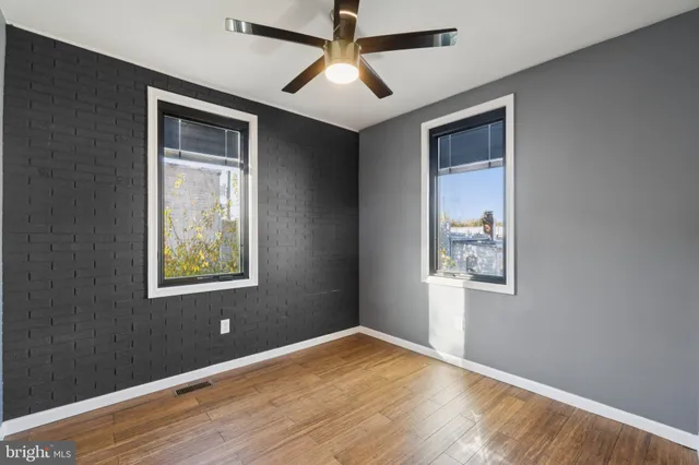 a view of an empty room with window and wooden floor