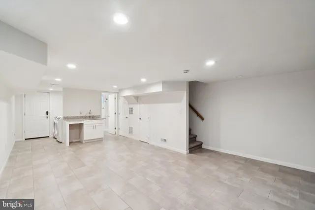 an empty room with a kitchen and a sink