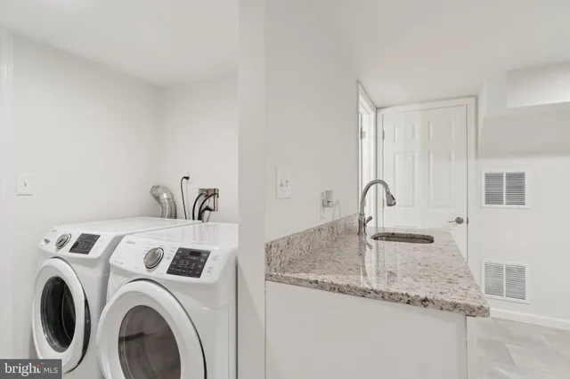 a utility room with sink dryer and washer