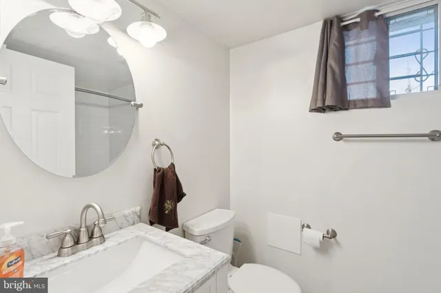 a bathroom with a toilet sink and mirror