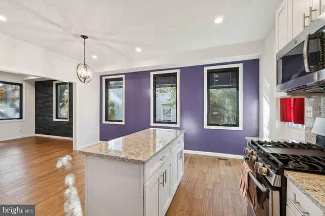 a kitchen that has a stove and a wooden floor