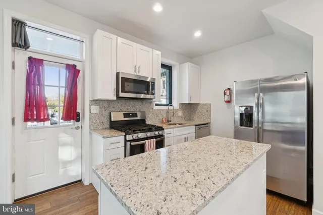 a kitchen with stainless steel appliances granite countertop a refrigerator stove microwave and sink