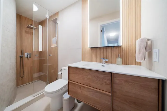 a bathroom with a sink a toilet and shower