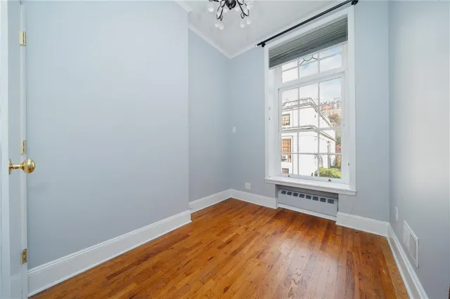 an empty room with a window and wooden floor