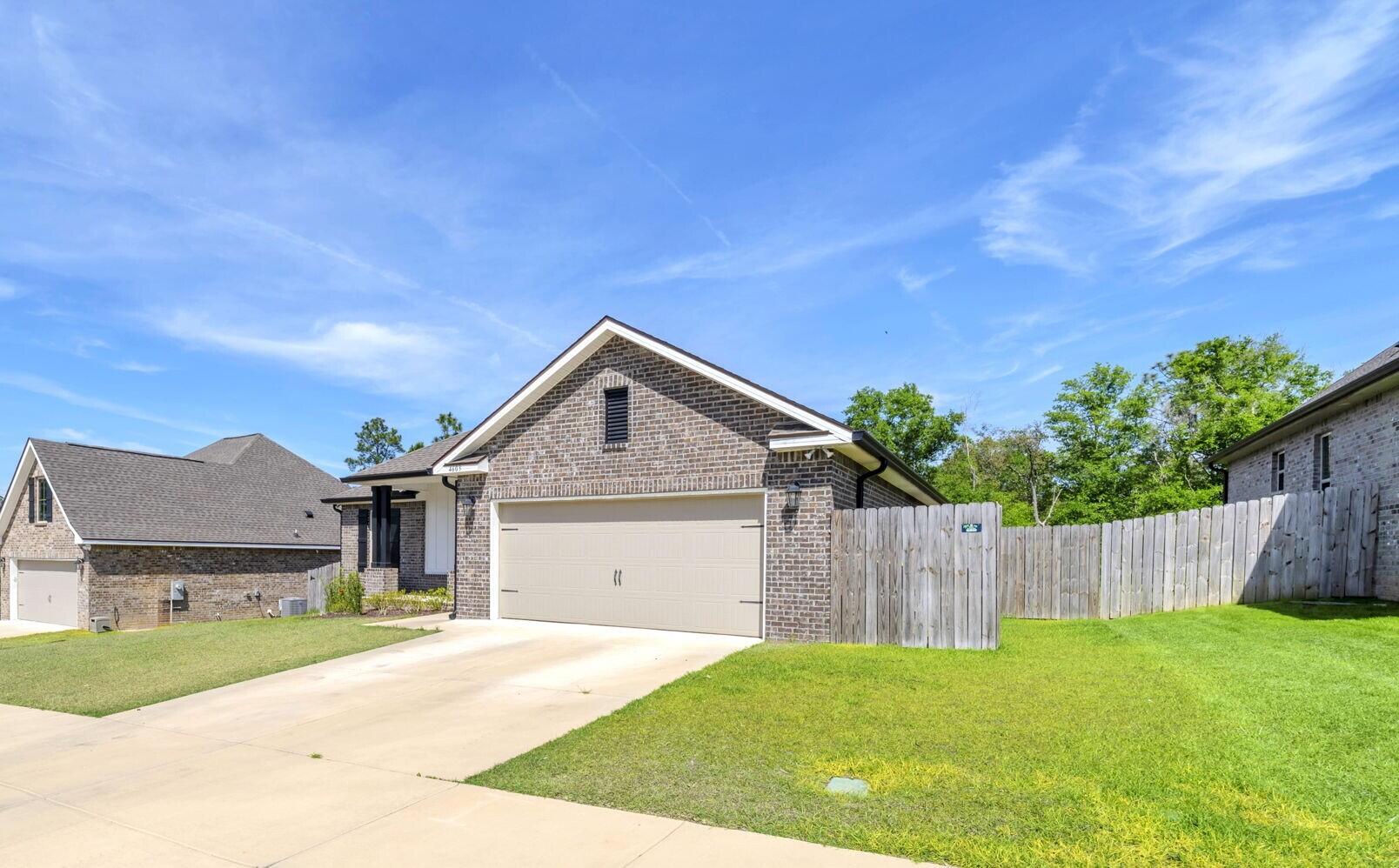 4603 Jayhawk Drive Crestview, FL 32539 - Photo 2 of 41 a front view of a house with a yard and garage