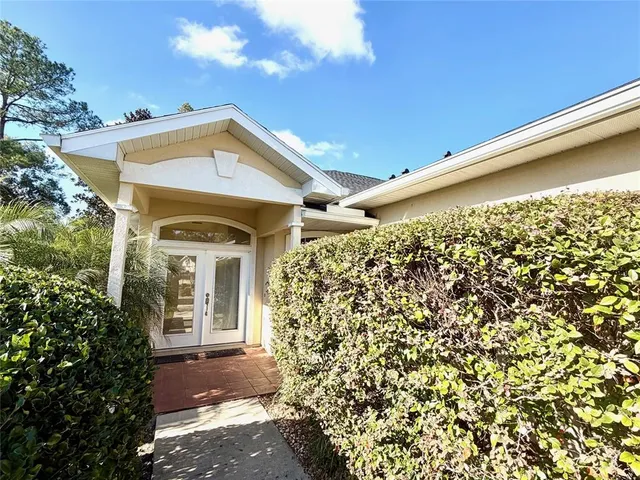 a view of a house with a large window and plants
