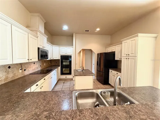 a kitchen with stainless steel appliances granite countertop a sink refrigerator and microwave