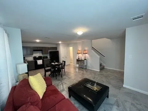 a living room with furniture and a wooden floor