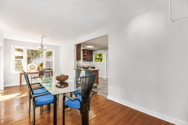 a dining room with furniture a chandelier and wooden floor