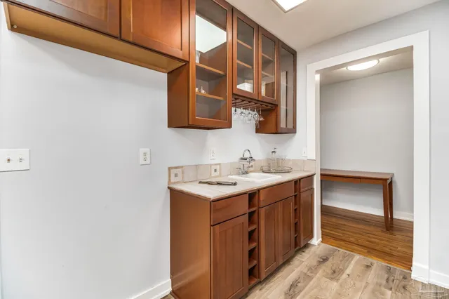 an empty room with wooden floor fan and a window