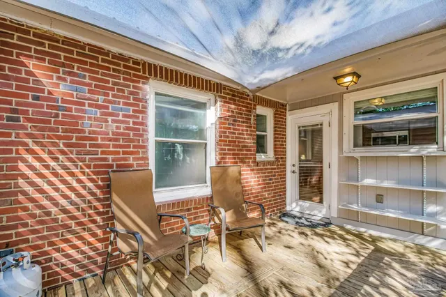 a view of a house with a yard and large tree