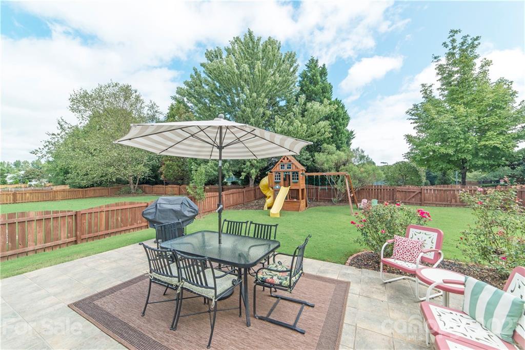 2605 Stirrup Ridge Lane Charlotte, NC 28270 - Photo 26 of 27 a view of a table and chairs under an umbrella in backyard