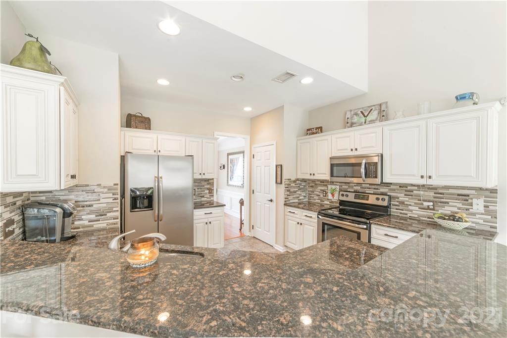2605 Stirrup Ridge Lane Charlotte, NC 28270 - Photo 8 of 27 a kitchen with stainless steel appliances a refrigerator a stove a sink a desk and chairs