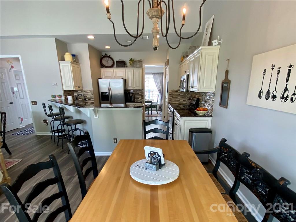 2605 Stirrup Ridge Lane Charlotte, NC 28270 - Photo 10 of 27 a kitchen with stainless steel appliances a dining table and chairs