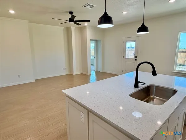 a kitchen with a sink a counter and a chandelier