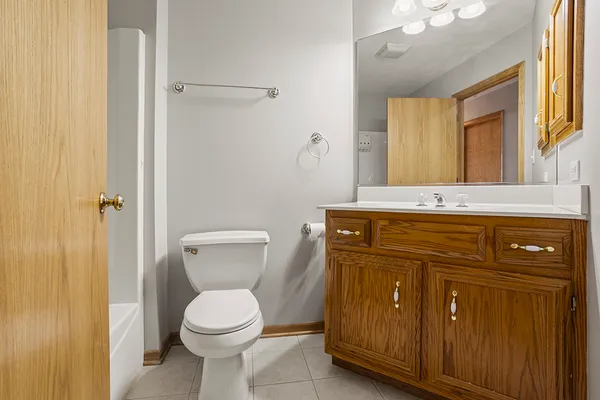 a bathroom with a toilet sink vanity and mirror