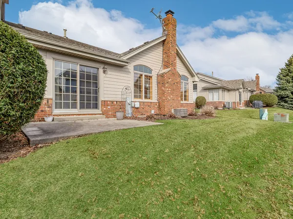 a front view of a house with a yard and trees