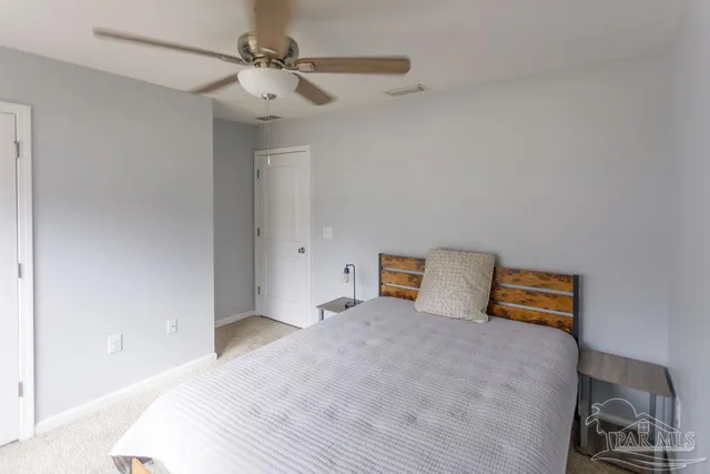 a bedroom with a bed and a ceiling fan