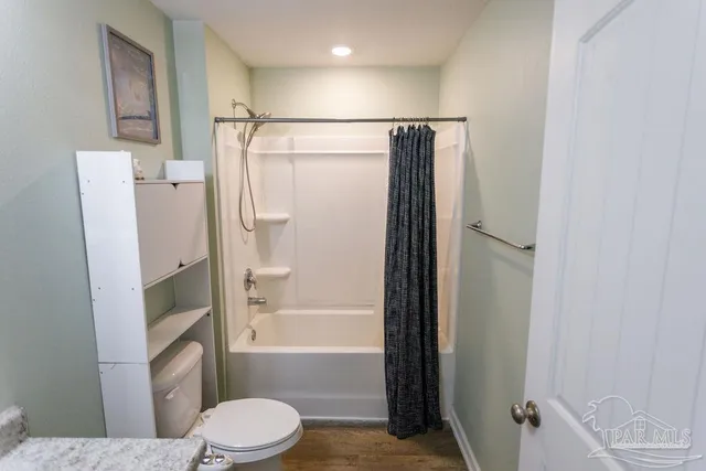 a bathroom with a granite countertop bathtub shower sink vanity and toilet