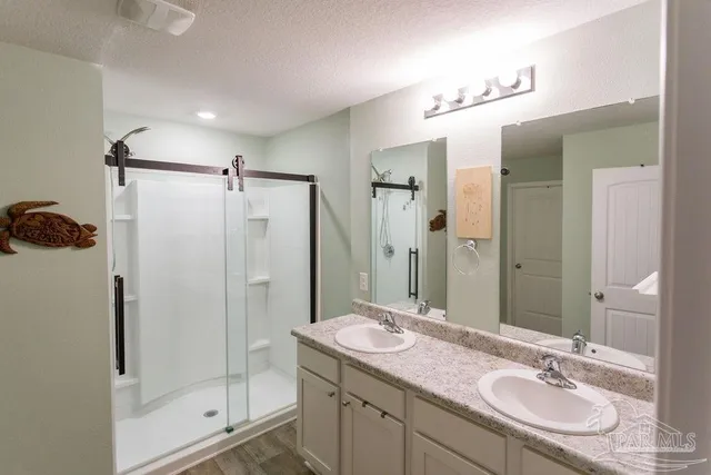 a bathroom with a shower sink vanity granite and mirror