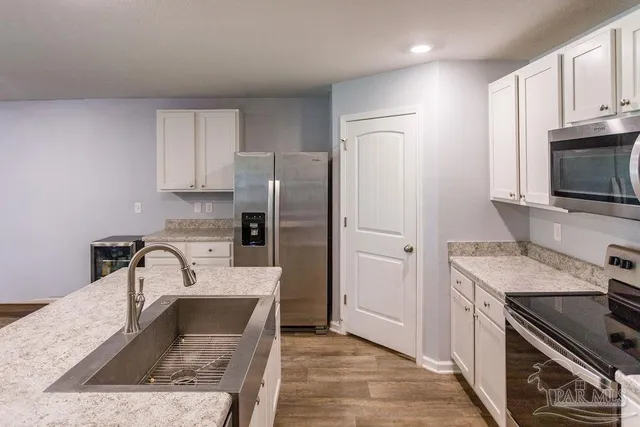 a kitchen with stainless steel appliances granite countertop a sink stove and refrigerator