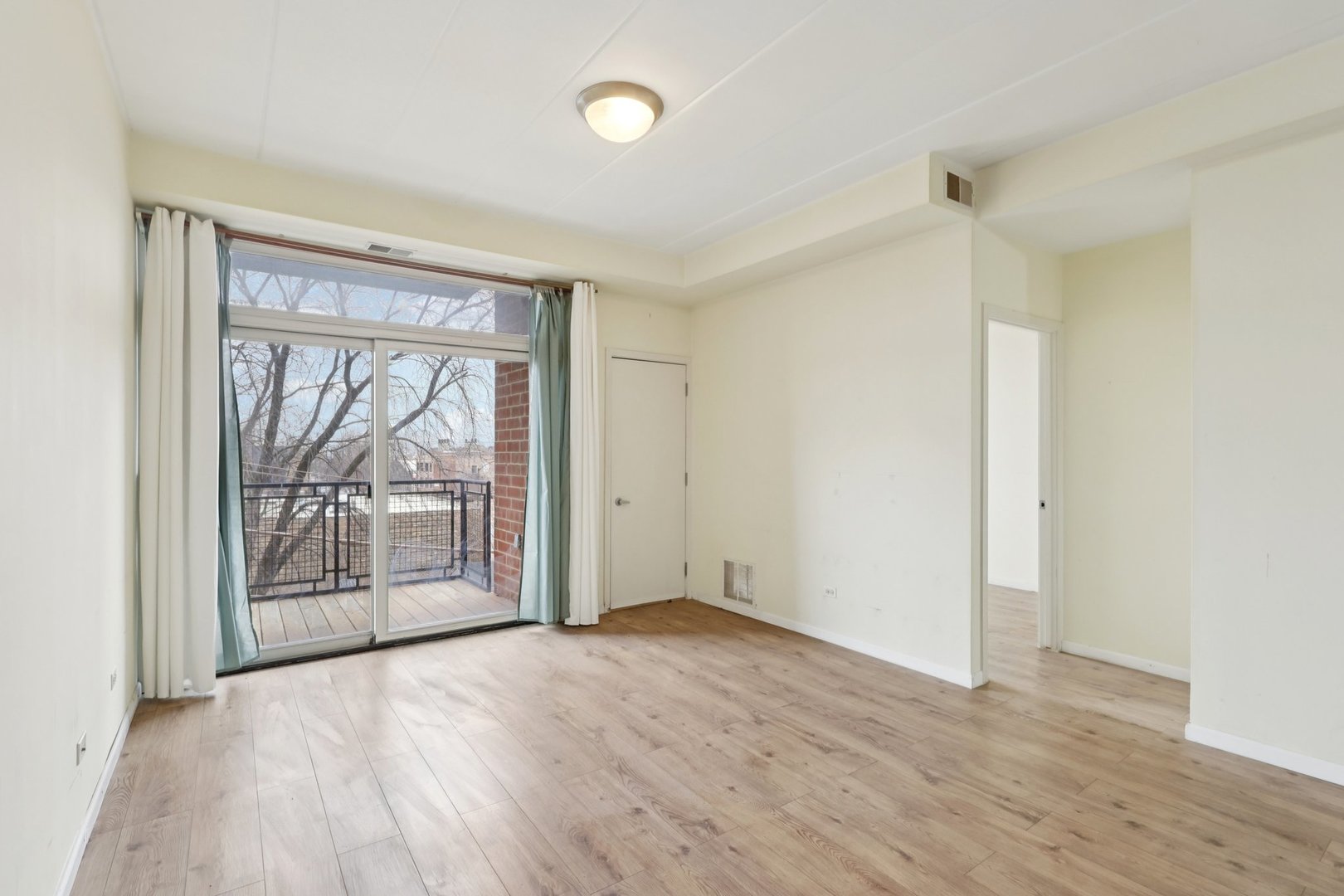 974 West 35th Place, Unit 302 Chicago, IL 60609 - Photo 6 of 22 an empty room with wooden floor and a window