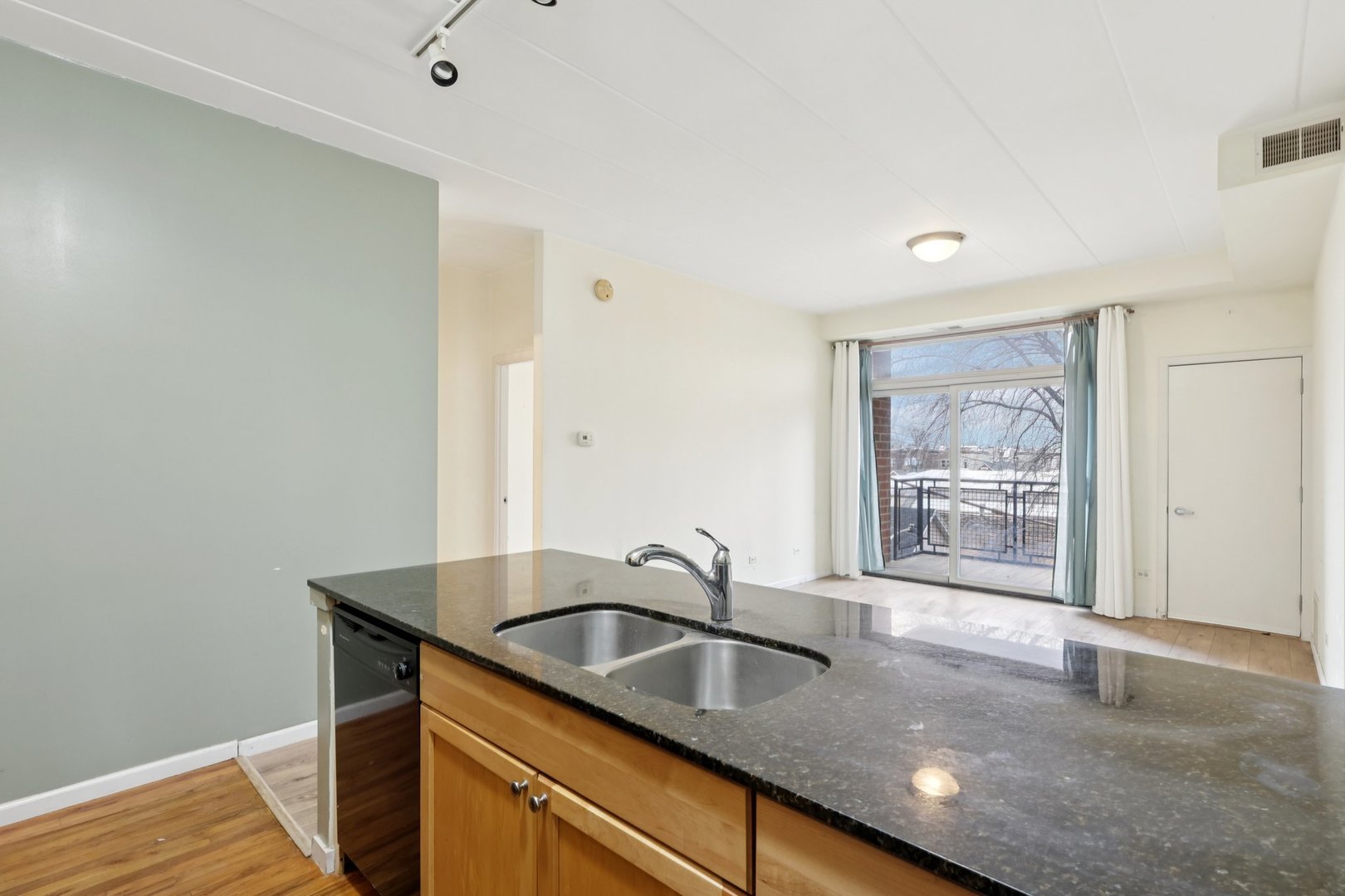 974 West 35th Place, Unit 302 Chicago, IL 60609 - Photo 7 of 22 a kitchen with granite countertop a sink and a wooden floor