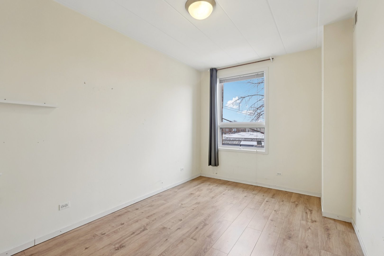 974 West 35th Place, Unit 302 Chicago, IL 60609 - Photo 10 of 22 a view of an empty room with wooden floor and a window