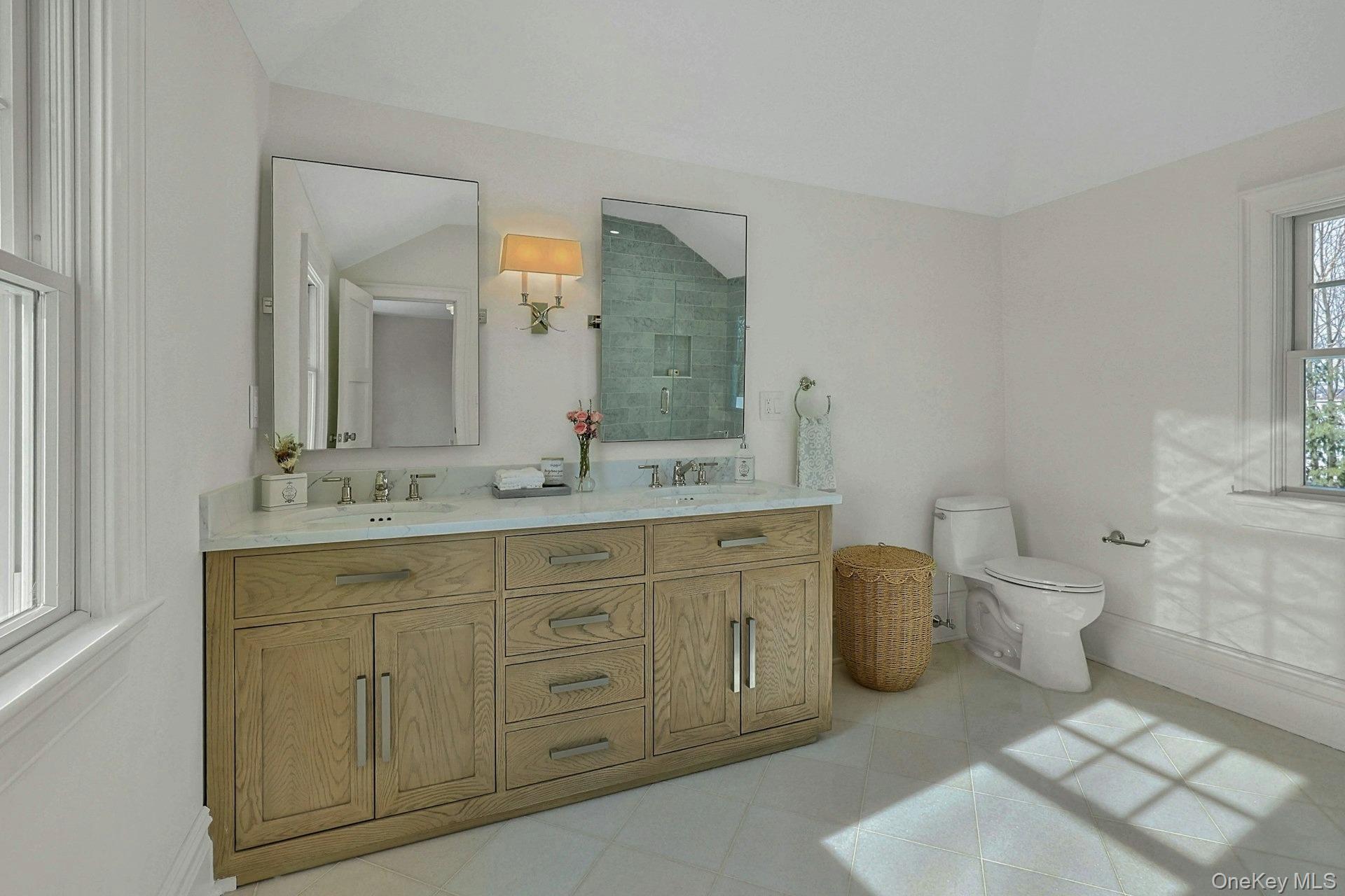 5 Henry Street Tuckahoe, NY 10707 - Photo 17 of 34 Luxurious ensuite primary bathroom with custom dual sink wood vanity and marble flooring.