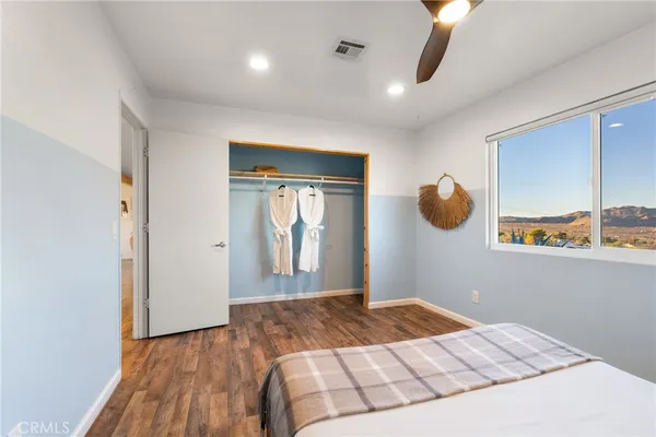 a bedroom with a bed and painting on the wall
