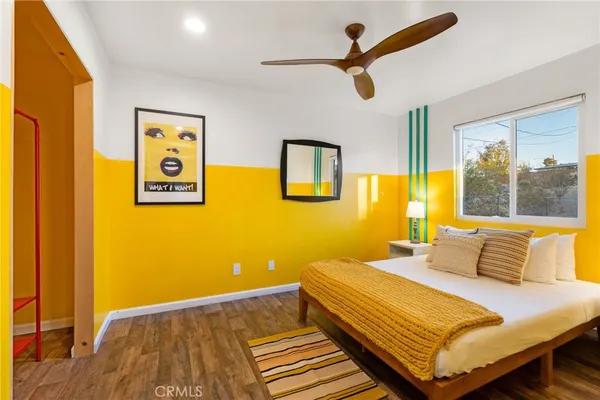 a bedroom with a bed and wooden floor
