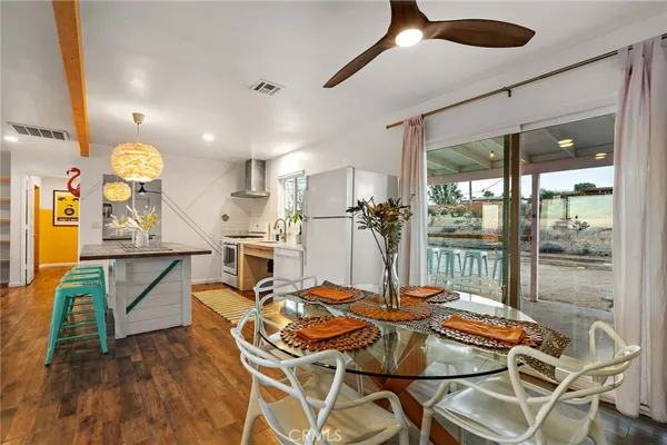 a dining room with furniture and a floor to ceiling window