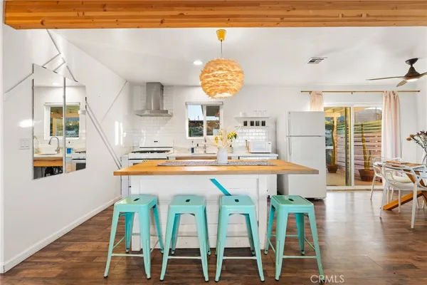 a very nice looking dining room with kitchen island granite countertop a table and chairs in it