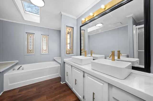 a bathroom with a tub a sink and a large mirror