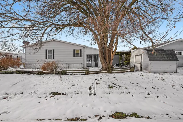 a front view of a house with a yard covered in snow