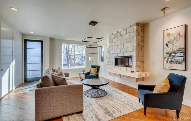 a living room with fireplace furniture and a large window