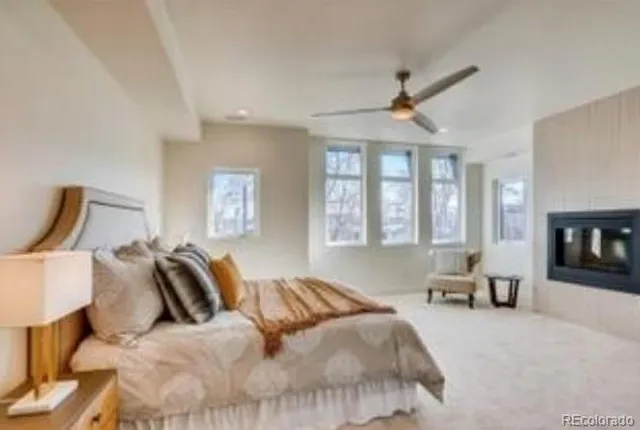 a bedroom with a bed couches and flat screen tv