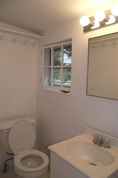 125 Shore Road, Unit 11 Truro, MA 02666 - Photo 4 of 8 a bathroom with a toilet a sink a mirror and a window