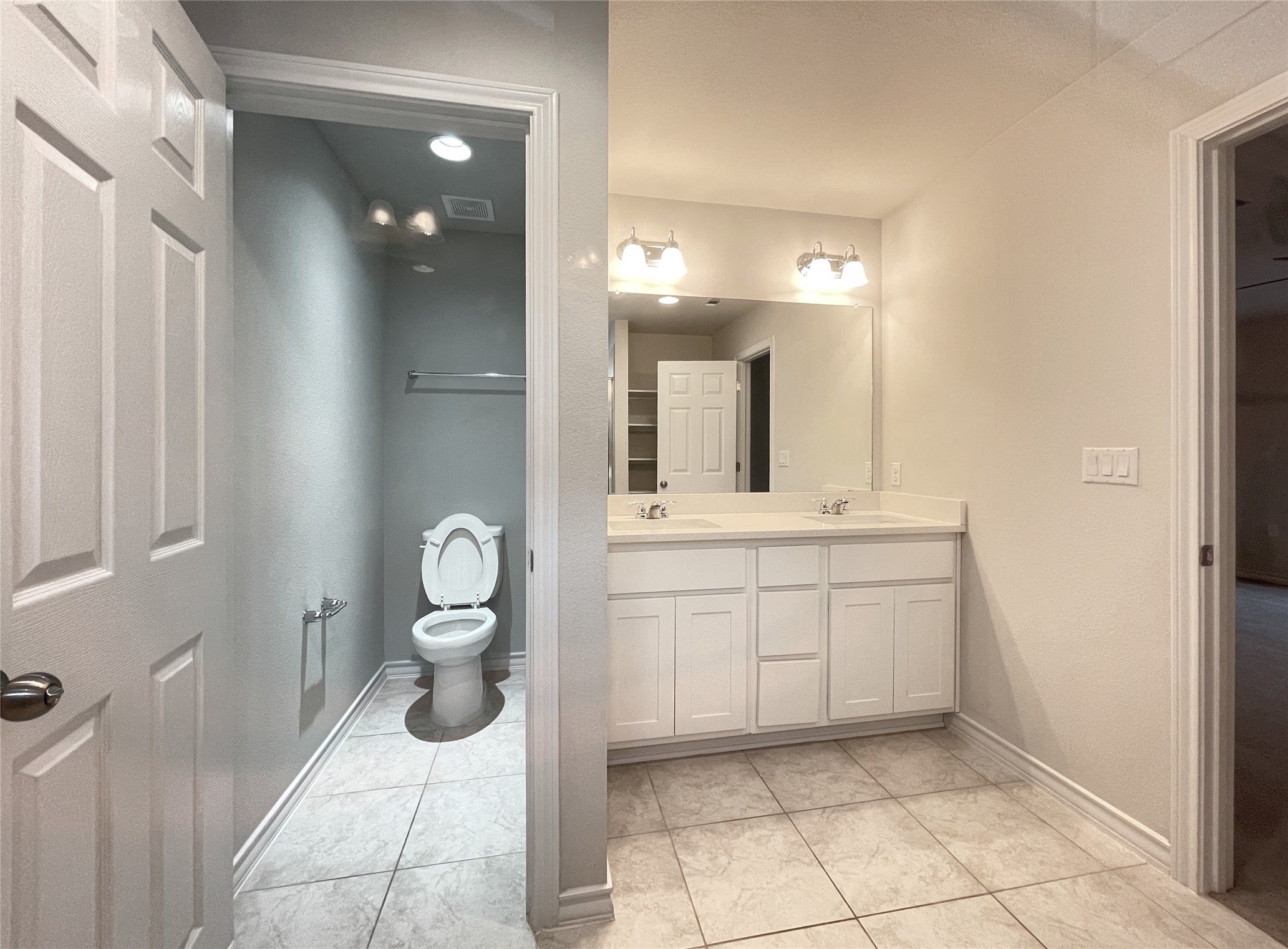 1602 Jacey Way Austin, TX 78725 - Photo 26 of 33 Bathroom with dual-sink vanity featuring white cabinetry and light-toned countertop