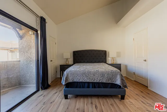 a bedroom with a bed and wooden floor