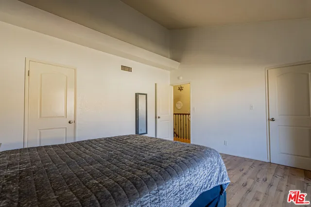 a bedroom with a bed and wooden floor