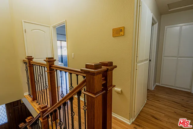a view of a hallway with wooden floor and staircase